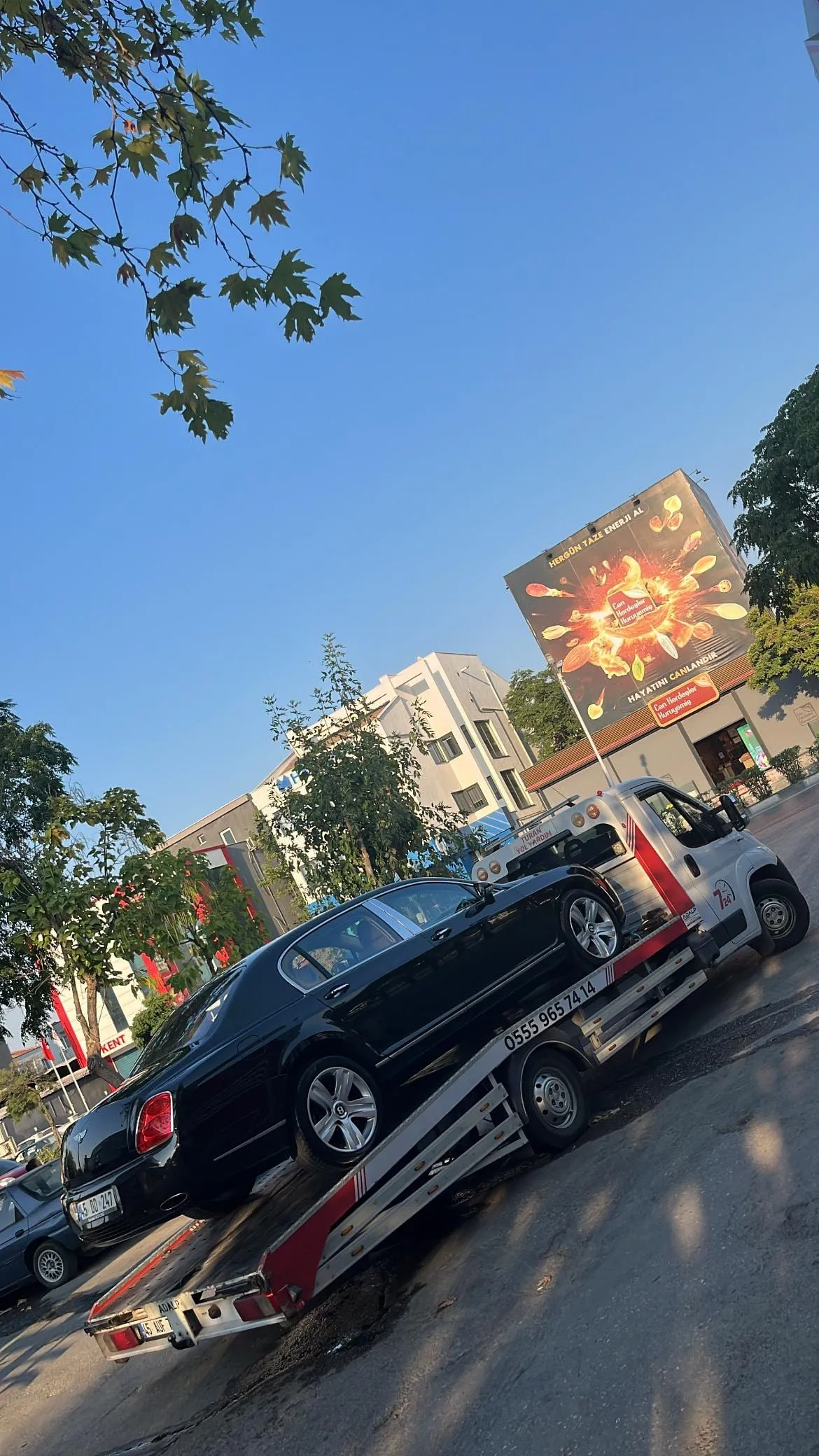 TURAN Yol Yardım kayar kasa çekicisinin eğik platformuna siyah Bentley yüklenirken
