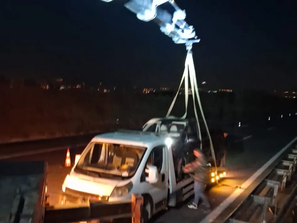 Vinç bomuyla sapanlara alınan araç kayar kasa çekiciye indirilirken — elektrikli araçta dört tekerleğin de yerden kesilmesini sağlayan yöntem